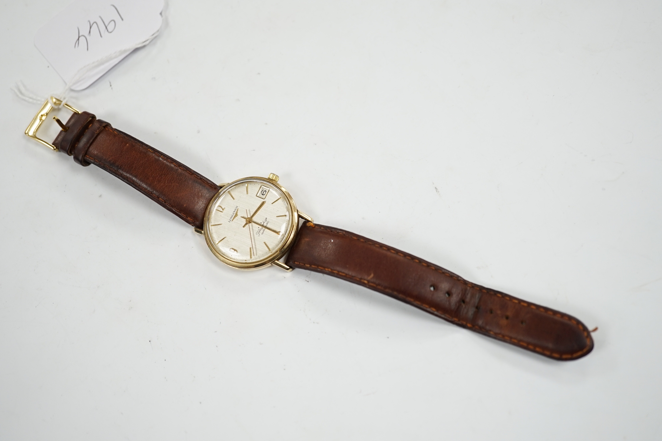 A gentleman's 9ct gold Longines Flagship automatic wrist watch, with baton numerals and date aperture, on associated leather strap.